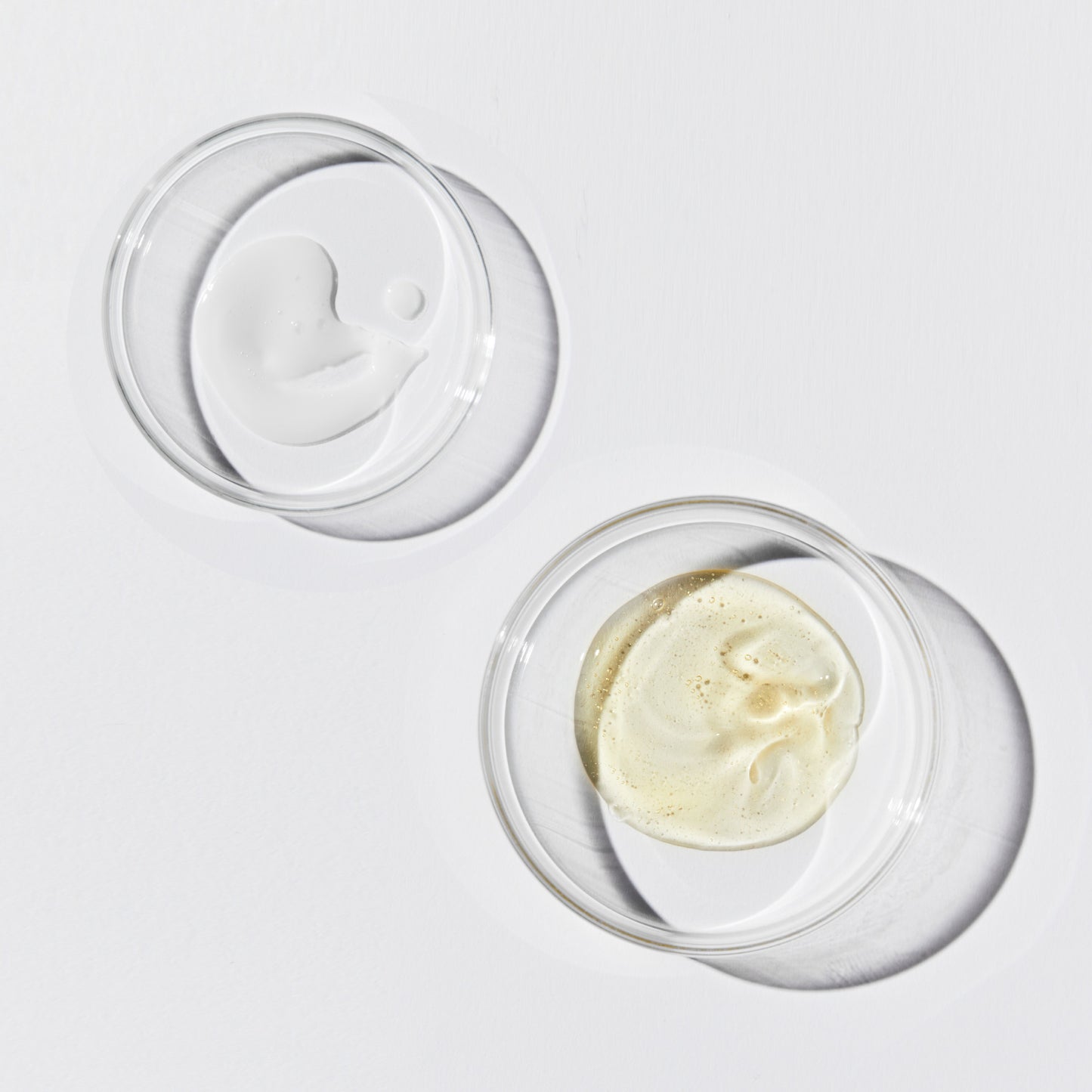 Two shallow, clear dishes. One contains a white opaque liquid, the other a translucent yellow liquid.